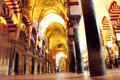Die ikonischen rot-weißen Bögen und Säulen im Inneren der Mezquita-Kathedrale in Córdoba, Spanien.