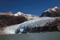 Beeindruckender Anblick eines Gletschers, der inmitten einer bergigen Landschaft ins Wasser kalbt.