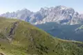 Aussicht auf die Dolomiten von einem bewachsenen Berghang.