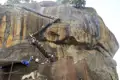 Besucher besteigen den Sigiriya Felsen über eine metallene Treppe.