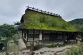 Traditionelles japanisches Haus mit einem Dach aus Moos und Gras.