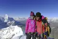 Bergsteiger erreichen den Gipfel und genießen den Ausblick auf die Bergkette.