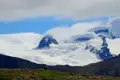 Gletscher mit dunklem Felsvorsprung und Wolken.