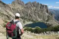 Wanderer mit Blick auf einen Bergsee inmitten einer felsigen Berglandschaft.