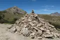 Ein Steinhaufen, der möglicherweise als Wegmarkierung dient, in einer Berglandschaft.