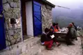 Wanderer pausieren an einer Berghütte und erfrischen sich.