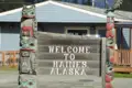 Ein Willkommensschild in Haines, Alaska, mit traditionellen Totempfählen.