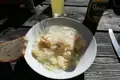 Kartoffelsalat mit Zwiebeln und Brot, begleitet von einem Gösser NaturRadler.