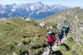 Wandergruppe auf einem Bergpfad in den Alpen.