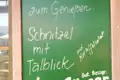 Schild mit der Aufschrift 'Schnitzel mit Talblick und Kartoffelsalat'.