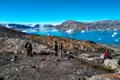 Wanderer auf einer Wanderung mit Blick auf einen Fjord voller Eisberge.