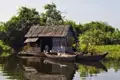 Kambodscha Radreise. Traditionelles schwimmendes Haus, umgeben von Bäumen und Pflanzen.