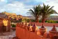 Dachterrasse mit Tongefäßen und Blick auf Ait Benhaddou, eine UNESCO-Welterbestätte in Marokko.
