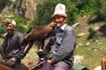 Traditioneller Adlerjäger mit seinem Steinadler auf einem Pferd.