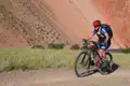 Mountainbiker auf einer Radtour entlang einer roten Felsformation.