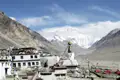Blick auf den Mount Everest von einem tibetischen Kloster aus. Gebetsfahnen und eine Stupa sind im Vordergrund sichtbar.