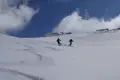 Zwei Skifahrer in Aktion auf einem schneebedeckten Hang.