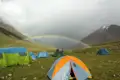 Campingplatz in den Bergen mit Regenbogen