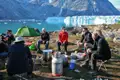 Reisende kochen und entspannen sich in der Nähe eines Gletschers während ihrer Reise.