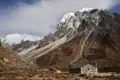 Eine einfache Berghütte und ein Zelt bieten Schutz während des Trekkings im Himalaya.