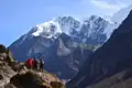 Wanderer auf einem Bergpfad mit Blick auf die schneebedeckten Gipfel des Himalayas.