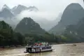 Ausflugsboot auf Flussfahrt inmitten einer Berglandschaft.