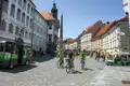 Radfahrer auf dem Platz in Ljubljana. Im Hintergrund sind historische Gebäude zu sehen.