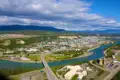 Panoramablick auf Whitehorse, Yukon, mit Fluss, Brücke, Gebäuden und Bergen.
