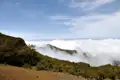 Aussicht von einem Bergpfad auf ein Wolkenmeer.