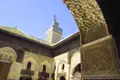 Architektur einer Medrese: Blick durch einen kunstvoll verzierten Bogen auf den Innenhof mit Minarett.