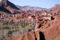Lehmhäuser eines Berberdorfes im Atlasgebirge, umgeben von roter Felslandschaft.