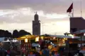 Marktstände mit Orangen und anderen Waren auf dem Djemaa el Fna in Marrakesch bei Sonnenuntergang. Die Koutoubia-Moschee ist im Hintergrund sichtbar.