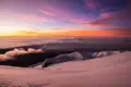 Sonnenaufgang über einer verschneiten Berglandschaft.