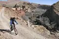 Mountainbiker auf einem Bergpfad in der Nähe einer traditionellen Siedlung.