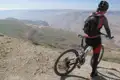 Mountainbiker auf einem Bergpfad mit Blick auf eine weite Landschaft.