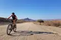 Mountainbiker auf einer Schotterpiste in einer trockenen, bergigen Landschaft.