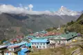 Bergdorf im Himalaya mit Blick auf einen schneebedeckten Gipfel.