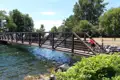 Radfahrer überquert eine Brücke über einen Fluss.
