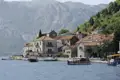 Montenegrinische Küstenstadt mit traditionellen Häusern und Booten im Hafen.