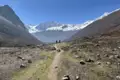 Wanderer auf einem Bergpfad im Himalaya mit Blick auf die schneebedeckten Gipfel.