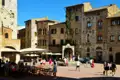 Mittelalterliche Piazza in San Gimignano mit umliegenden Gebäuden und Touristen.