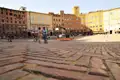 Gepflasterter Piazza del Campo in Siena mit umliegenden historischen Gebäuden.