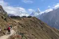 Wanderer auf einem Bergpfad mit Blick auf die schneebedeckten Gipfel des Himalayas.