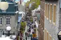 Belebte Fußgängerzone in Quebec City mit historischen Gebäuden und vielen Menschen.