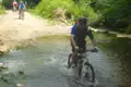 Mountainbiker durchfährt einen Fluss auf einer Radtour.