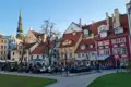 Historische Altstadt von Riga mit Restaurant im Vordergrund und der St. Petri Kirche im Hintergrund.