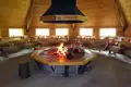 Lagerfeuer in einer Hütte mit gedeckten Tischen.