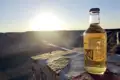 Eine Flasche Cider bei Sonnenuntergang über einer Schlucht.