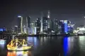 Nachtsicht auf die Skyline von Shanghai mit einem beleuchteten Schiff auf dem Fluss.