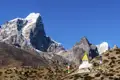 Gebetsfahnen und eine Stupa vor der beeindruckenden Kulisse des Himalayas.